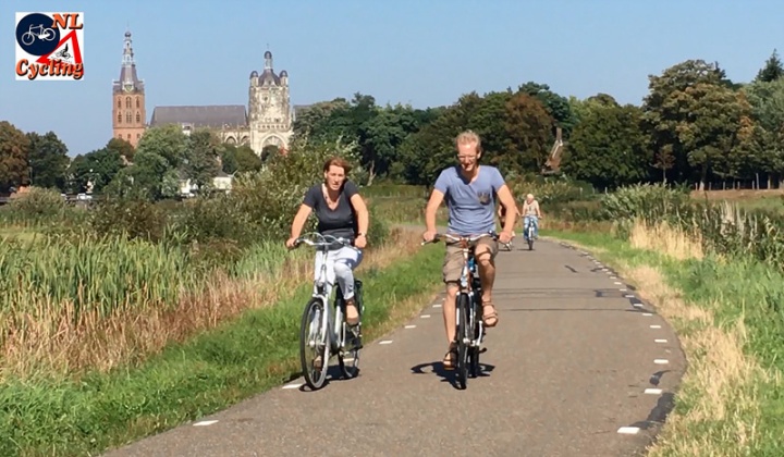 Cycling with the 's-Hertogenbosch cathedral in the background.